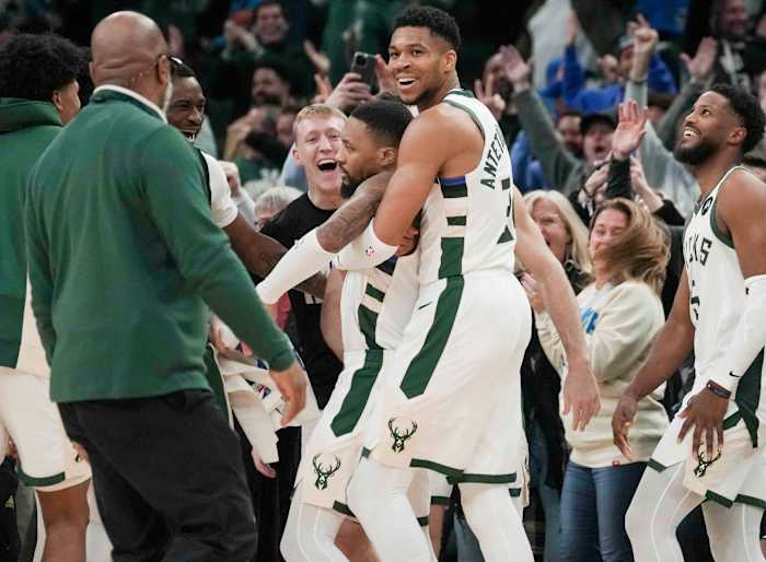 Bucks guard Damian Lillard gets a hug from Giannis Antetokounmpo
